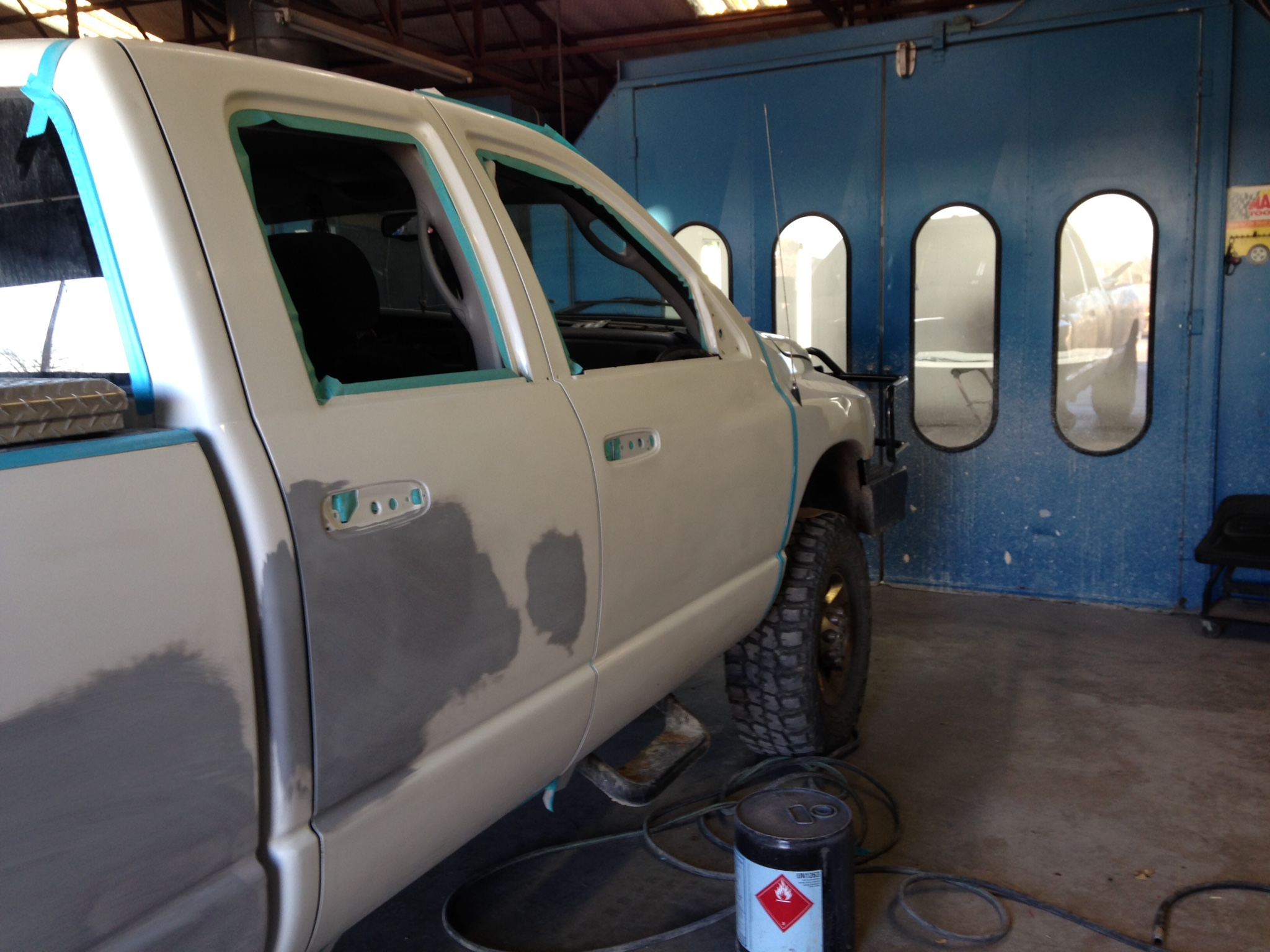 A truck masked and staged for paint work inside Campbell's Auto Body's paint booth in Stephenville, TX